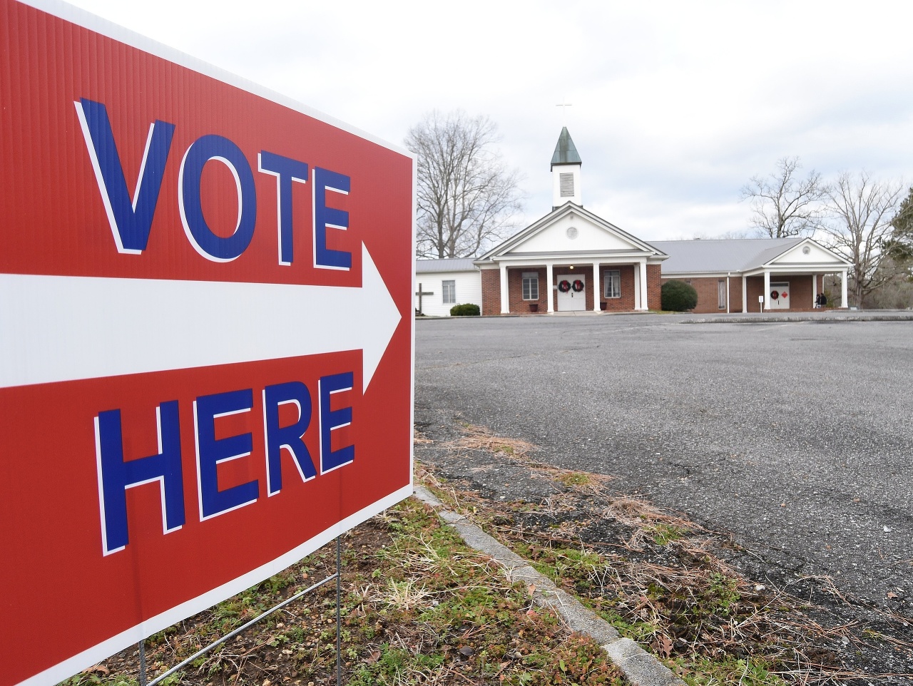 Nápis na ulici usmerňuje voličov do volebnej miestnosti zriadenej v miestnom kostole počas hlasovania v druhom kole volieb do Senátu v americkom štáte Georgia v meste Dawnville