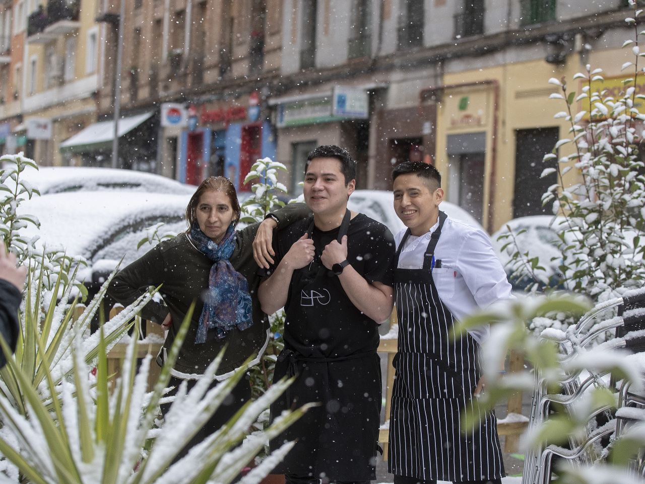 Zamestnanci reštaurácie sa fotia na terase počas sneženia v Madride
