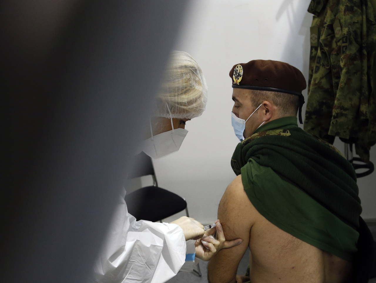 Vojak dostáva vakcínu proti ochoreniu COVID-19 od čínskej spoločnosti Sinopharm v Belehrade