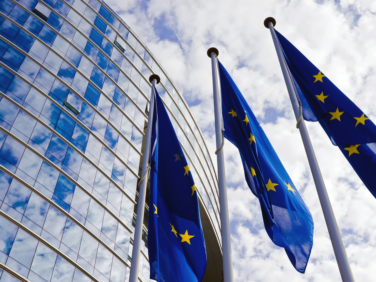 Vlajky EÚ pred budovou EK.