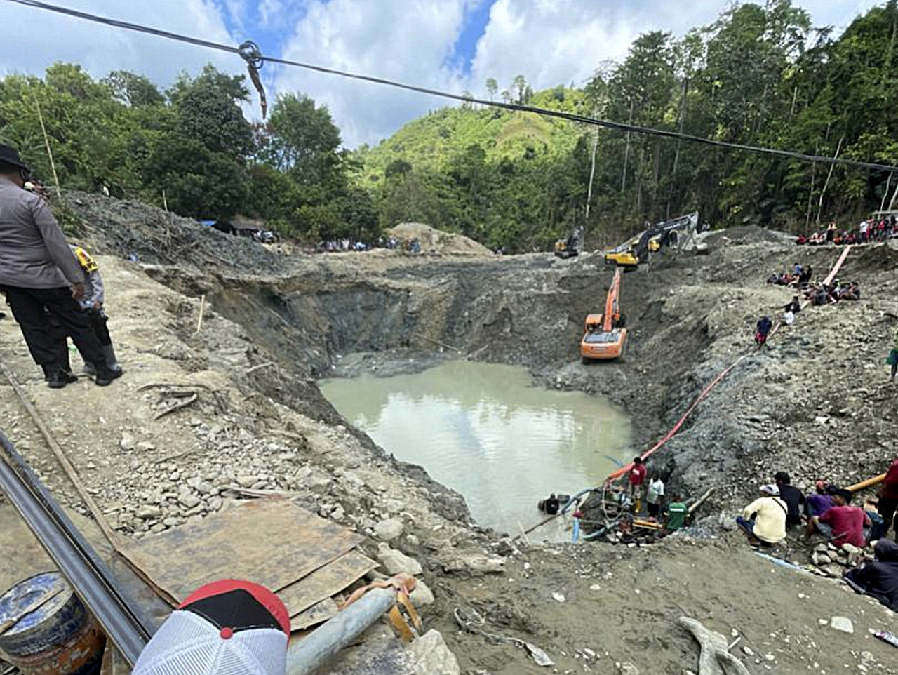 Záchranári odčerpávajú vodu z nelegálnej bane na zlato, ktorú zasiahol zosuv pôy v indonézskej provincii.