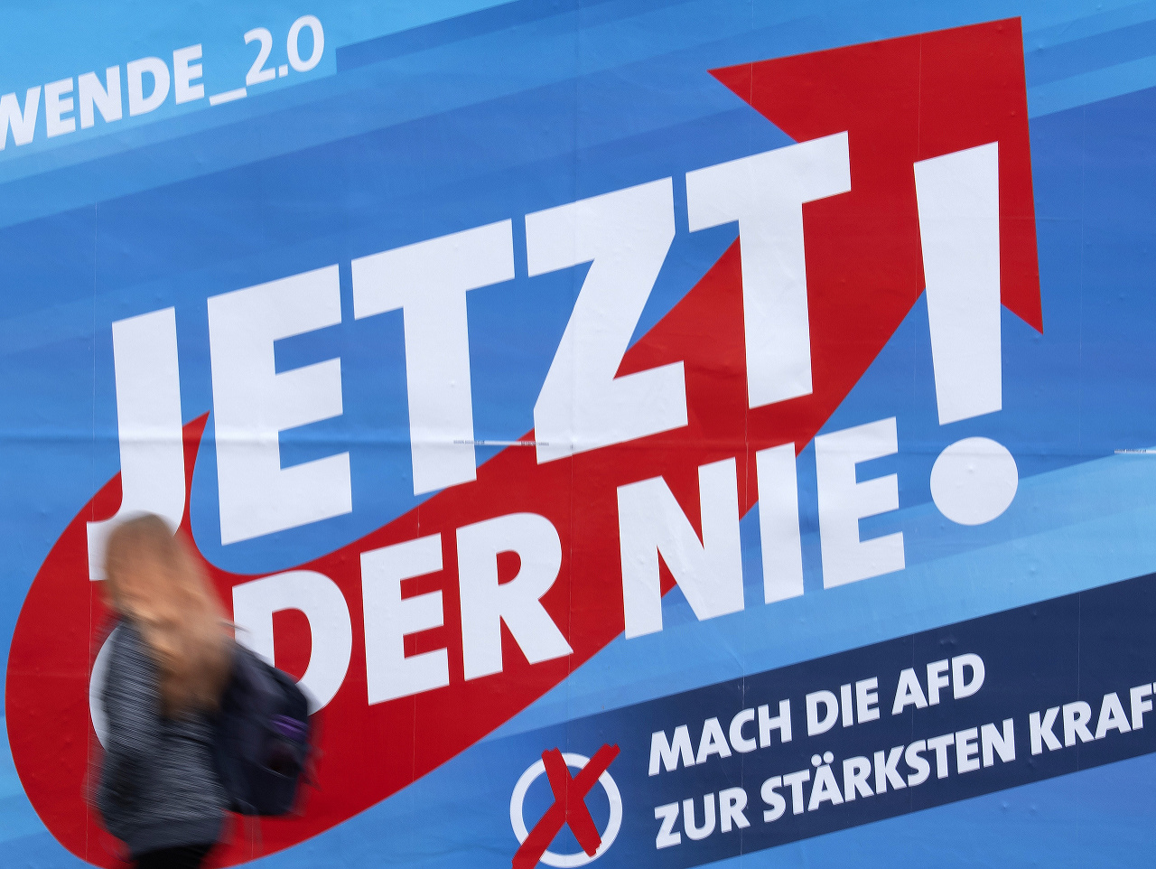 Žena prechádza okolo volebného plagátu strany Alternatíva pre Nemecko (AfD)