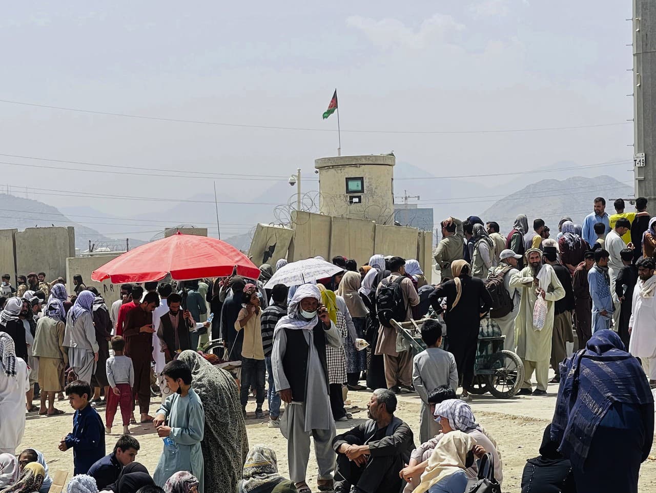 Ľudia čakajúci pred letiskom v Kábule