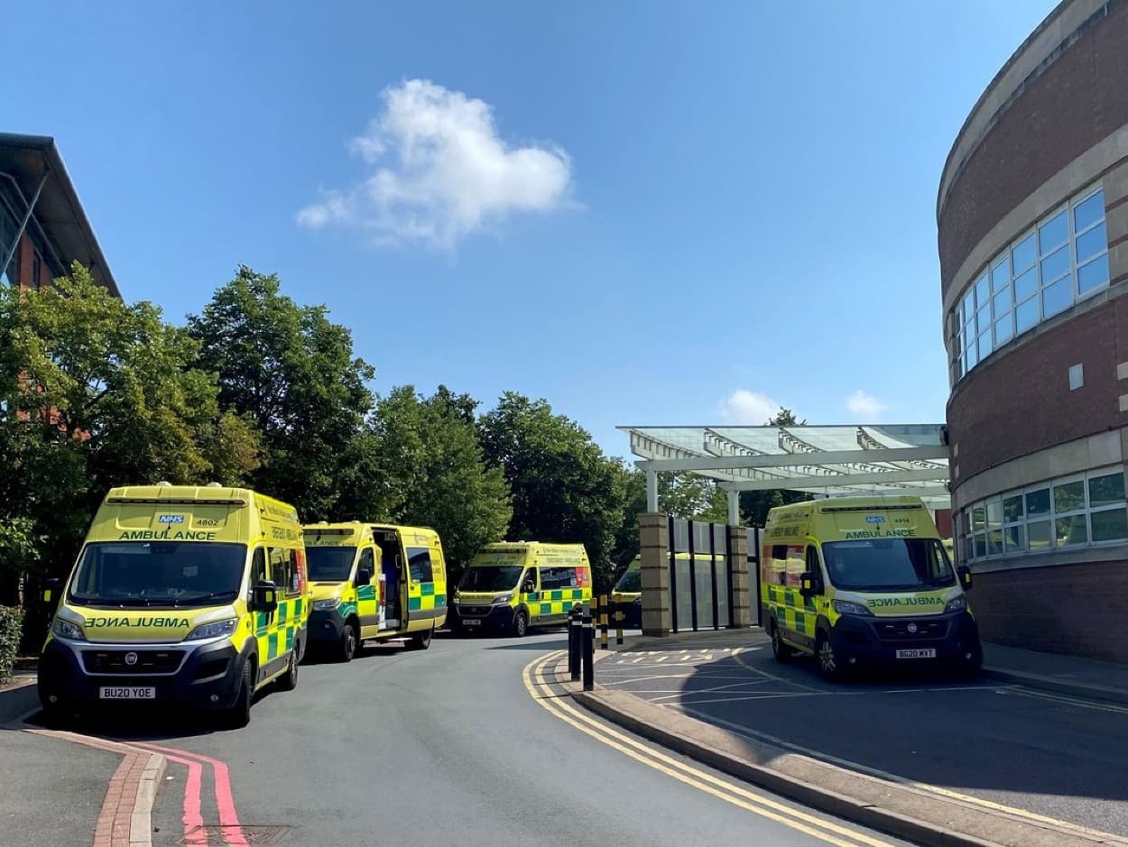 Sanitky čakajú spolu s pacientmi pred Worcestershire Royal Hospital, kým ich preberie pohotovosť.
