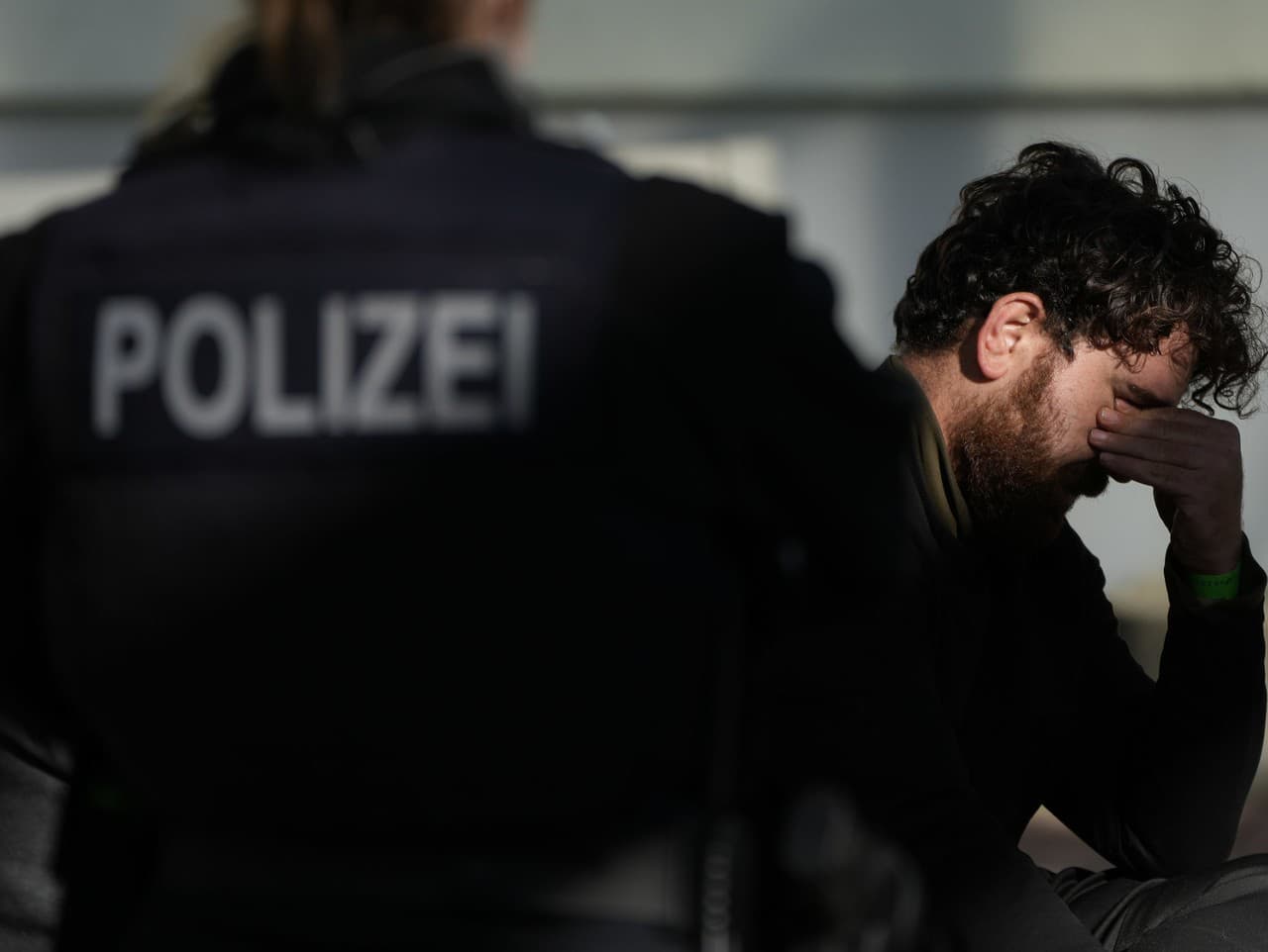 Policajtka stráži zadržaného migranta na policajnej stanici na nemecko-poľskej hranici v meste Frankfurt nad Odrou