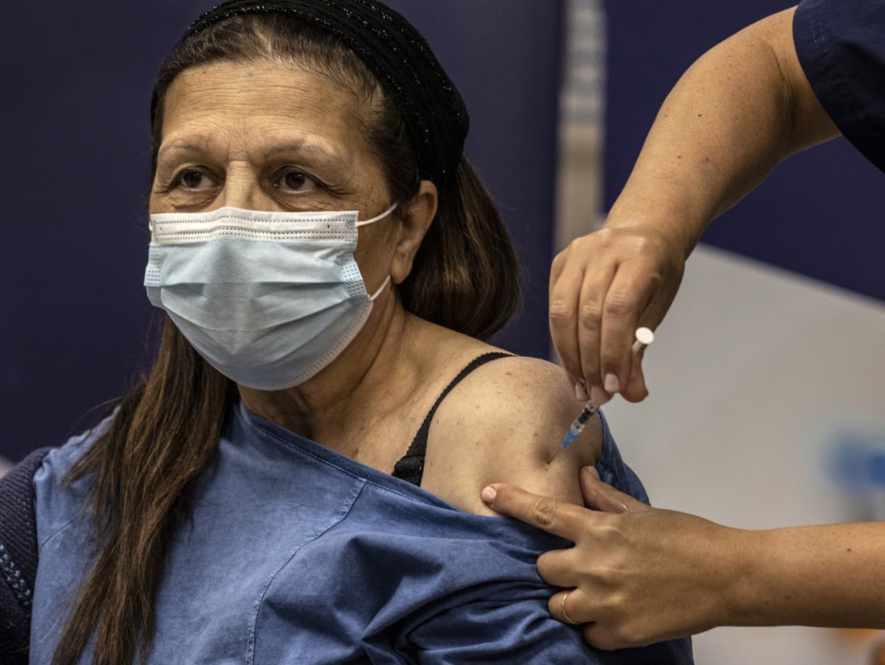 Žena dostáva štvrtú dávku očkovacej látky Pfizer/BoNTech