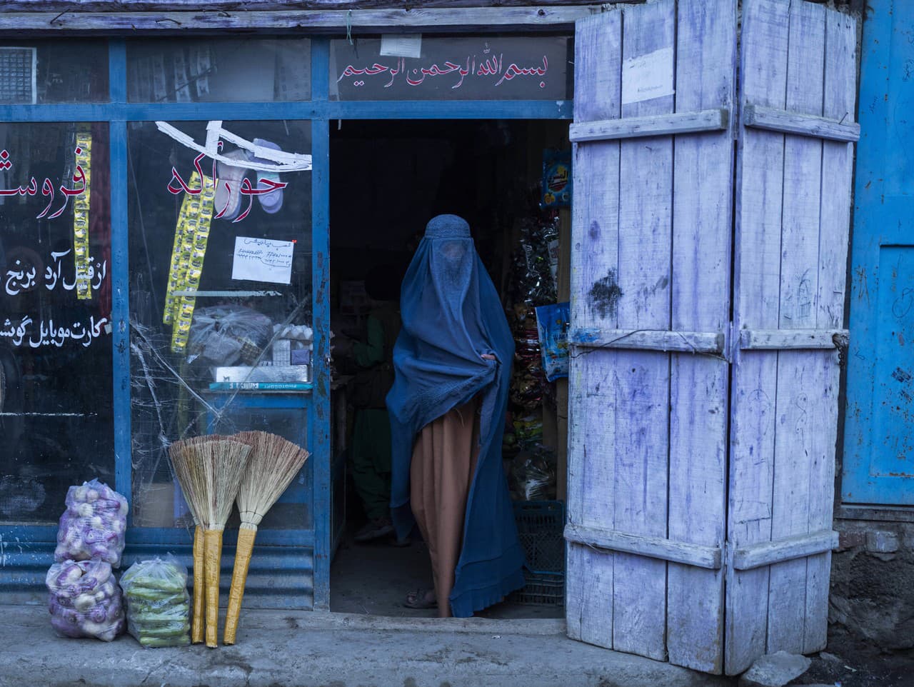 Afganská žena vychádza z obchodu so zmiešaným tovarom v Kábule