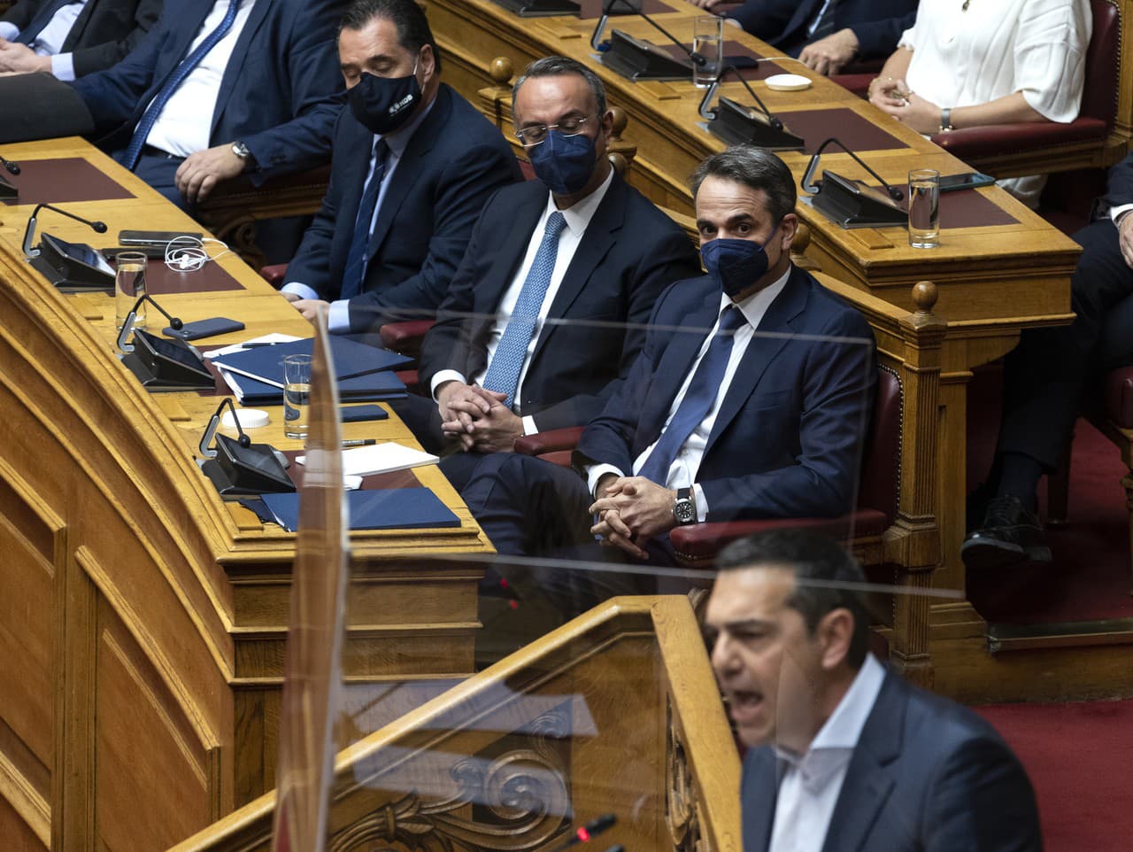 Grécky premiér Kyriakos Mitsotakis počúva rozprávať opozičného lídra Alexisa Tsiprasa