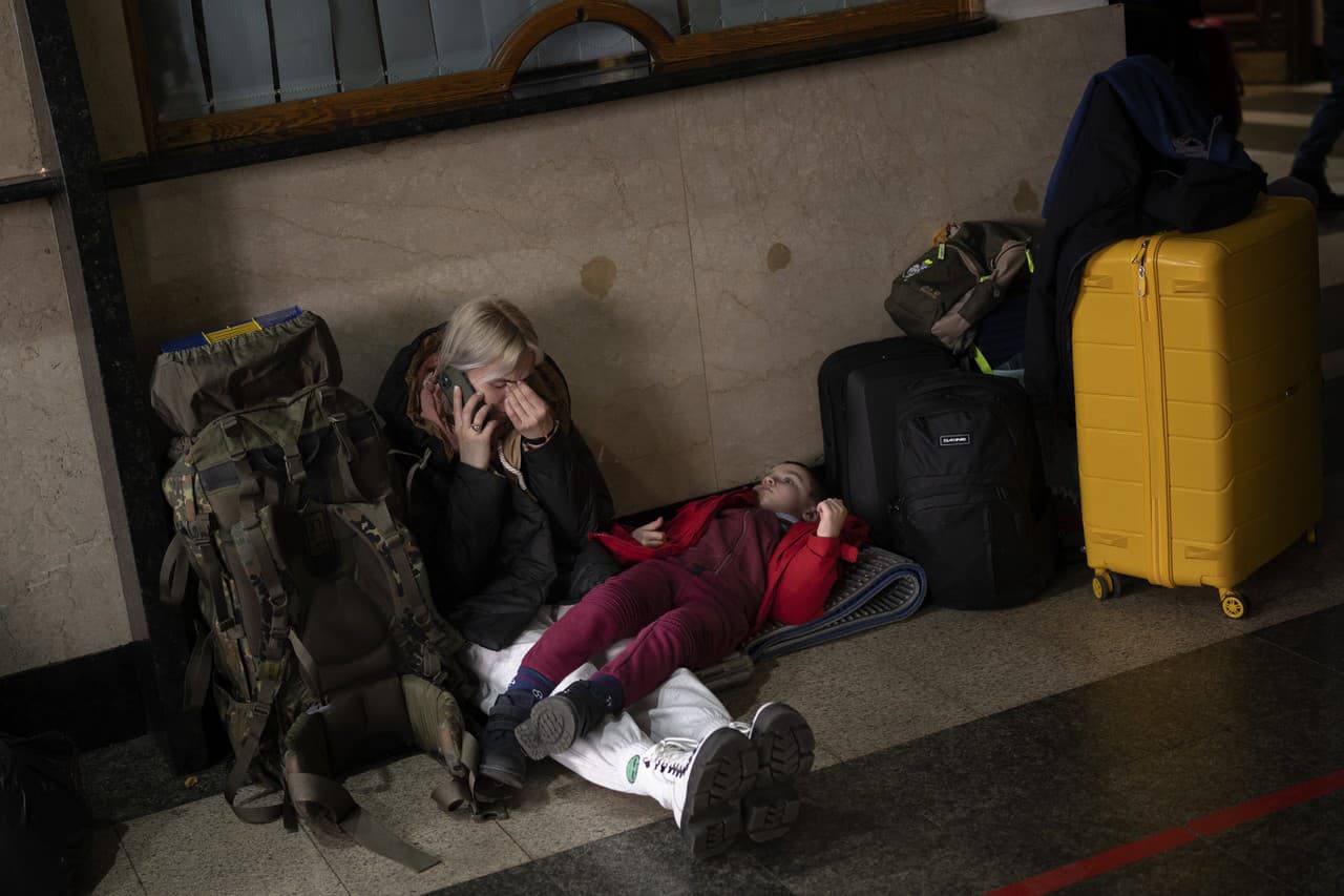 Žena s dievčaťom čakajú na vlak v Kyjeve. 