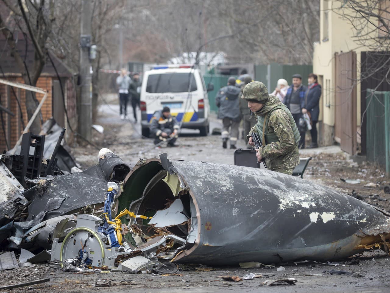 Vojak ukrajinskej armády kontroluje úlomky zostreleného lietadla v Kyjeve na Ukrajine v piatok 25. februára 2022.