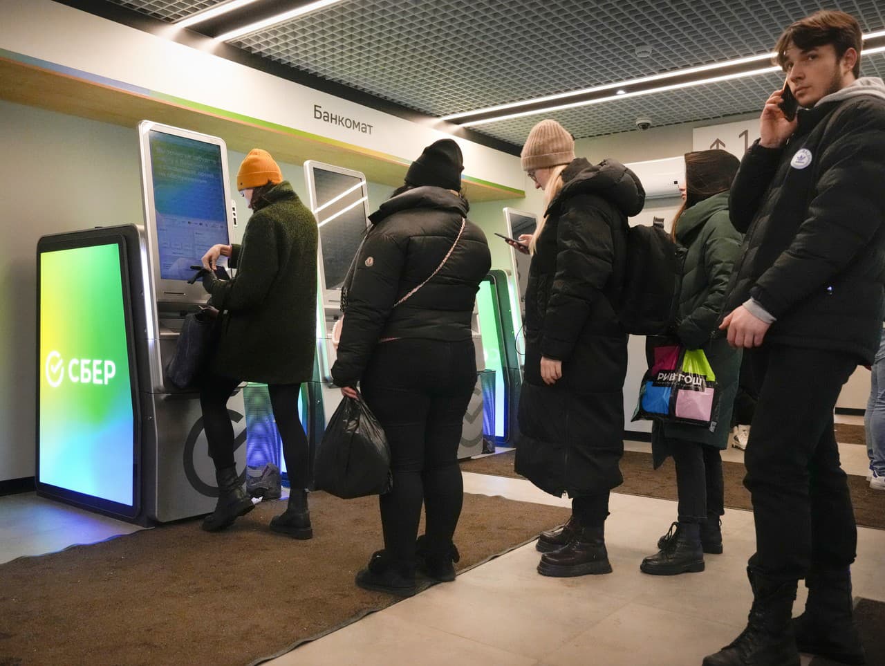 Ľudia vyťahujú peniaze z bankomatu Sberbank