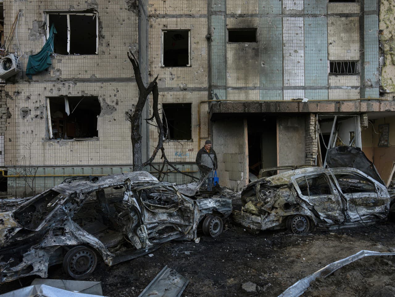 Pohľad na zničené autá a budovu v Kyjeve