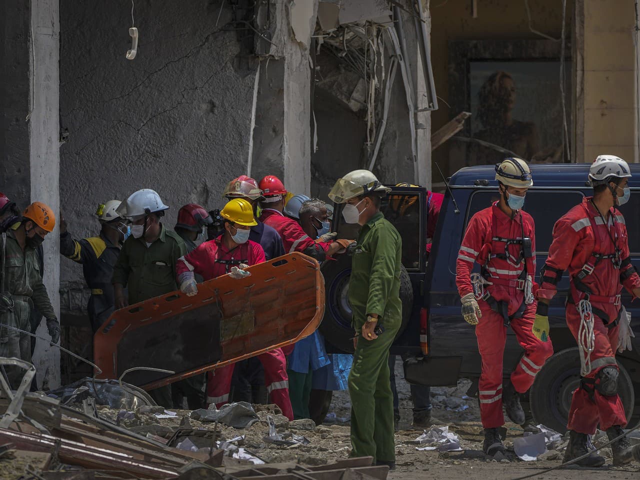 Záchranári nesú nosidlá po nájdení tela v troskách mieste explózie