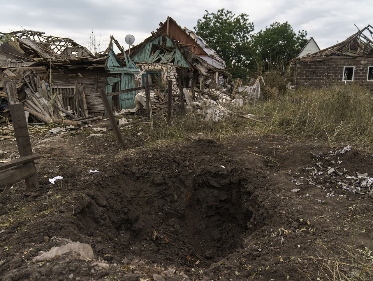 Kráter po ruskom raketovom útoku pri zničených domoch v meste Kramatorsk