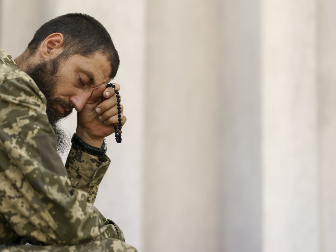 Ukrajinský vojak sa modlí ruženec.