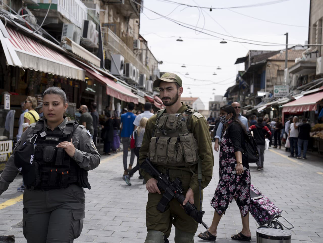 Dôstojníčka izraelskej pohraničnej polície vľavo hliadkuje so svojím armádnym náprotivkom na trhu Mahane Yehuda v Jeruzaleme v rámci sprísnených bezpečnostných opatrení, v nedeľu 3. apríla 2022. Napätie v posledných dňoch prudko vzrástlo po tom, čo palest