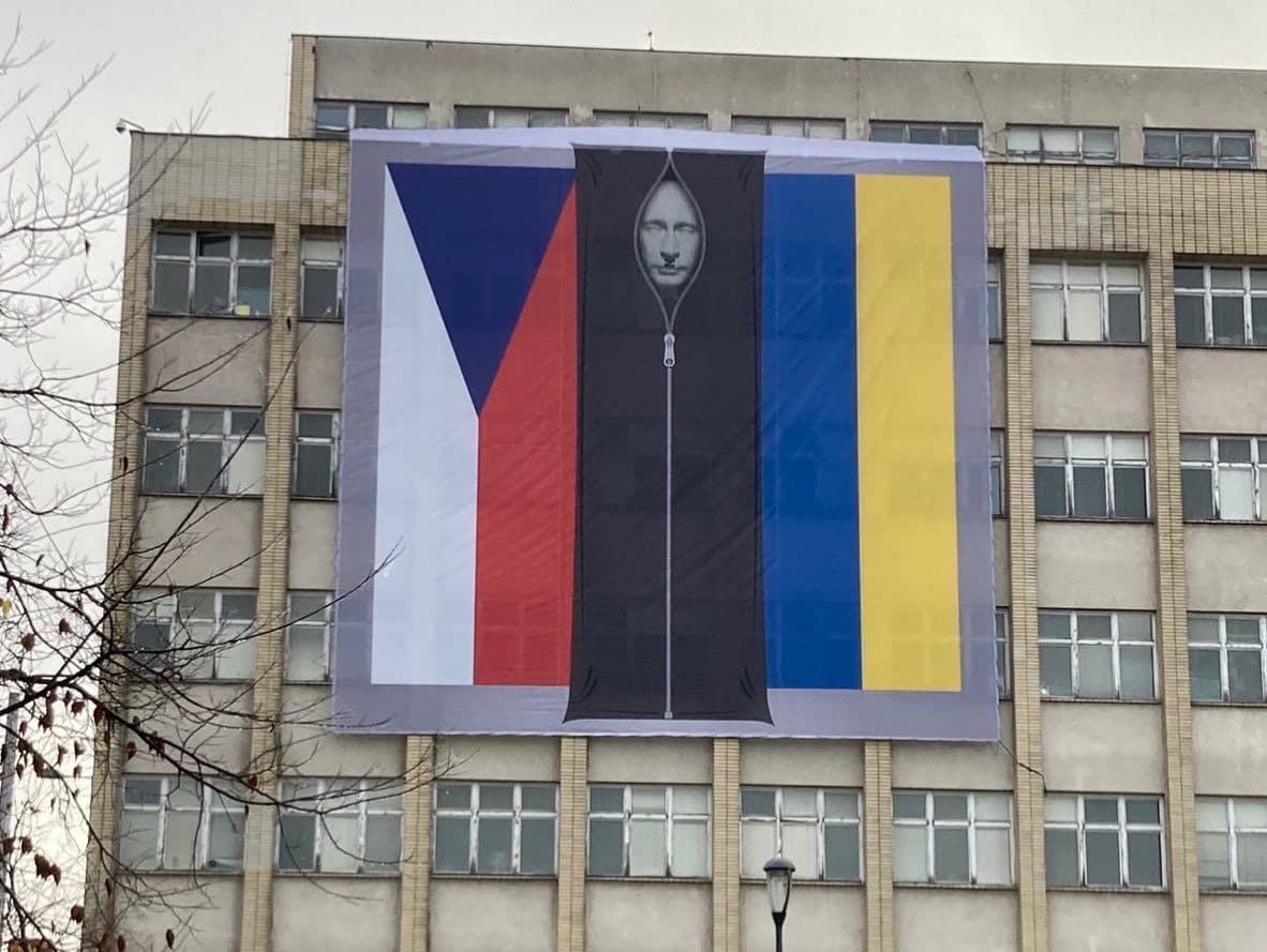 Medzi vlajkami Českej republiky a Ukrajiny sa vyníma mŕtvy prezident Vladimir Putin. 
