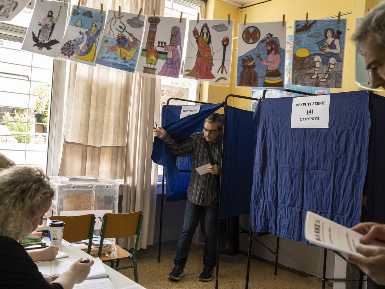 Volič odovzdáva svoj hlas vo volebnej miestnosti v Aténach.