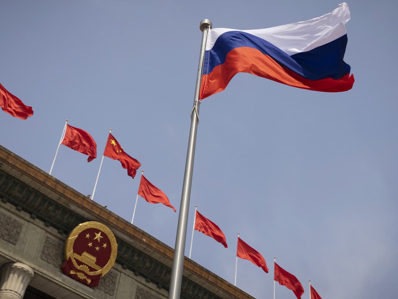 Ruská vlajka v popredí a v pozadí čínske vlajky
