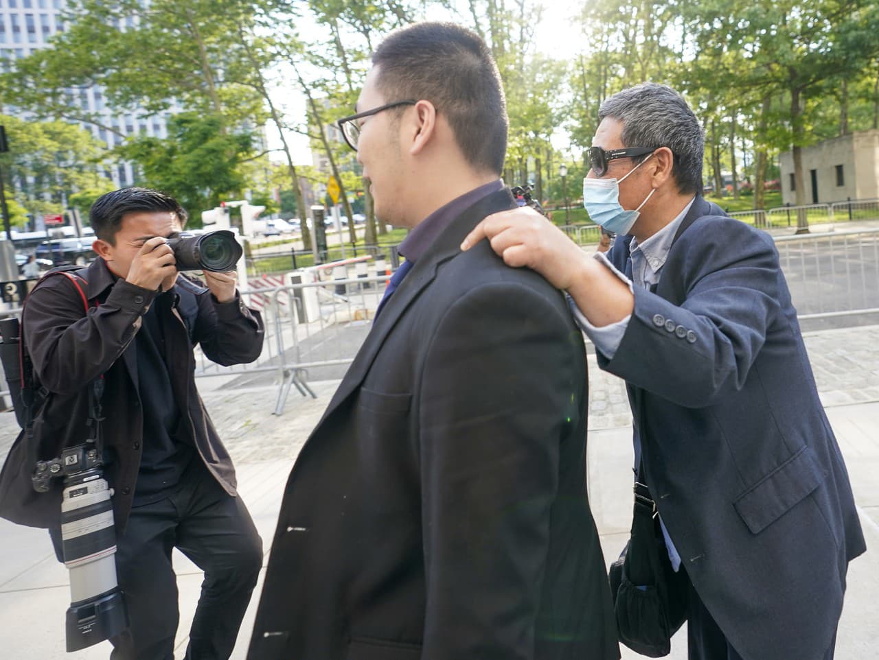 Zhu Yong (vpravo) sa snaží chrániť pred fotografmi, keď opúšťa federálny súd v Brooklyne