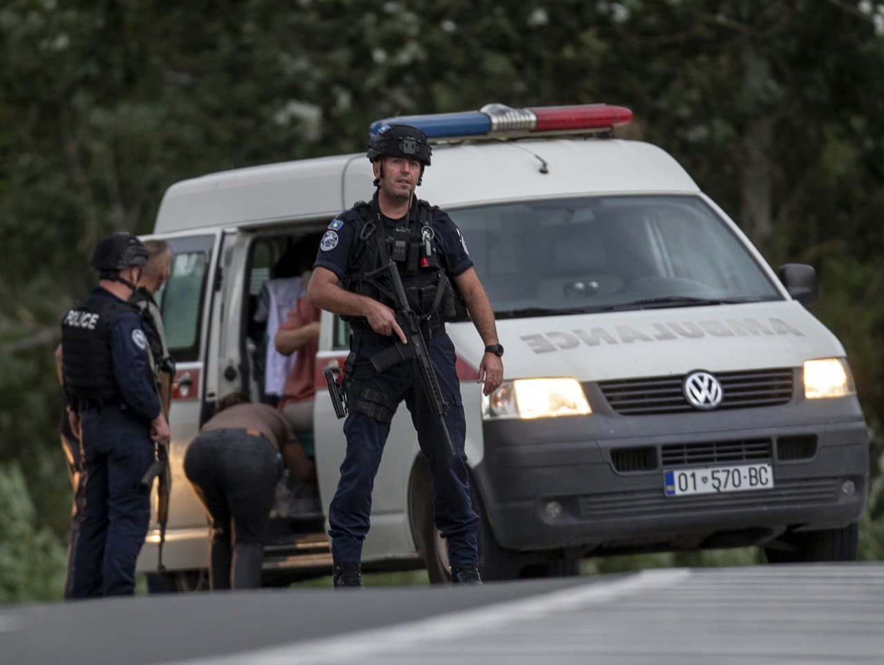 Kosovskí policajti evakuujú zranenú osobu na križovatke vedúcej ku kláštoru Banjska v obci Banjska.