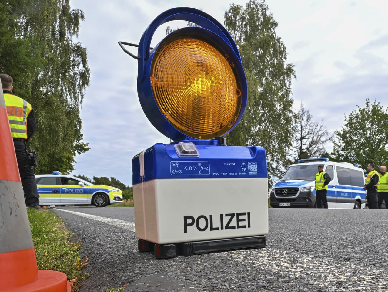 Výstražný signál stojí na ceste počas policajnej kontroly proti pašovaniu migrantov v nemeckom Roggosene 
