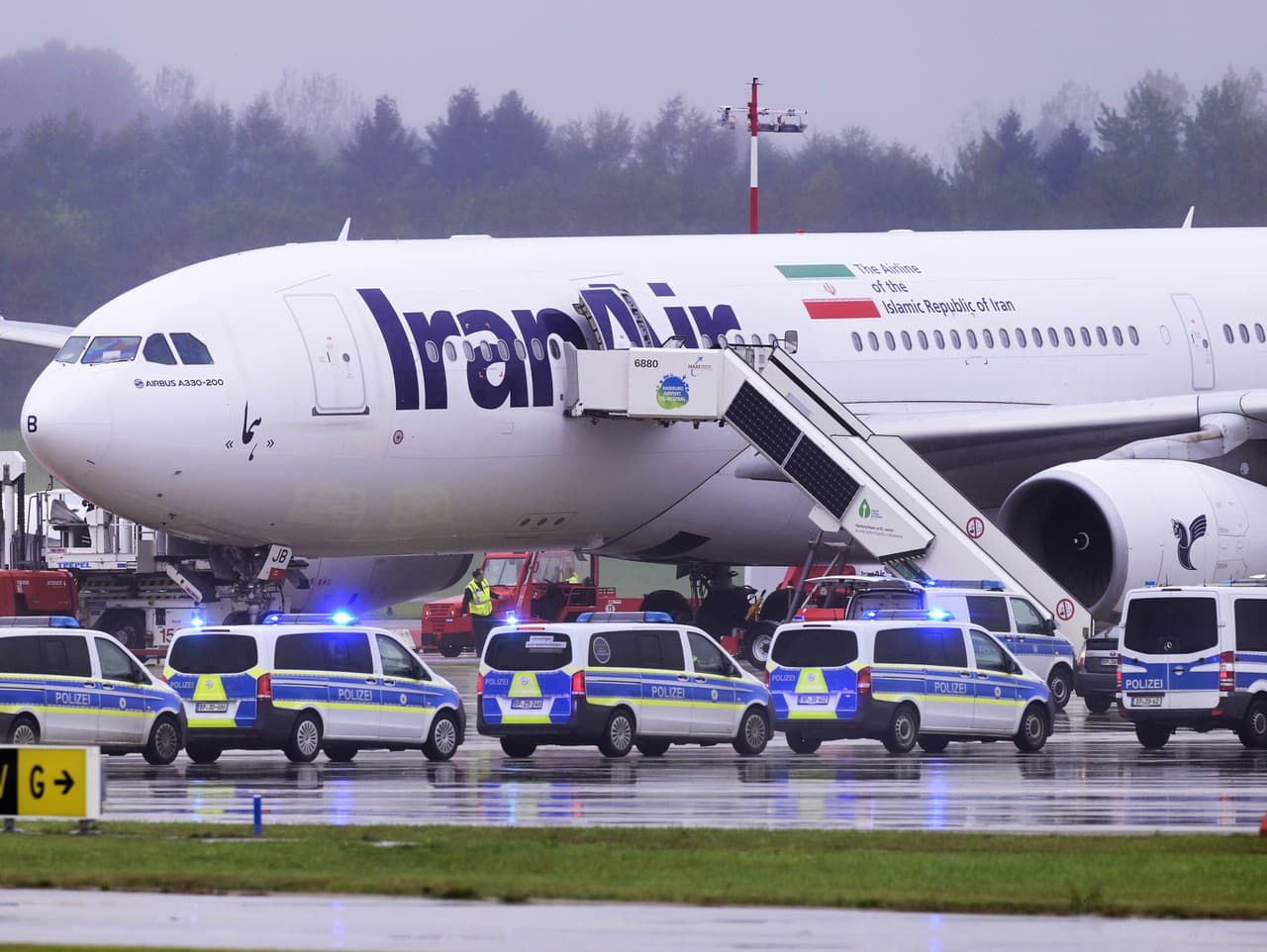 Policajné autá zastavili pred lietadlom spoločnosti Iran Air na letisku v Hamburgu 9. októbra 2023. 