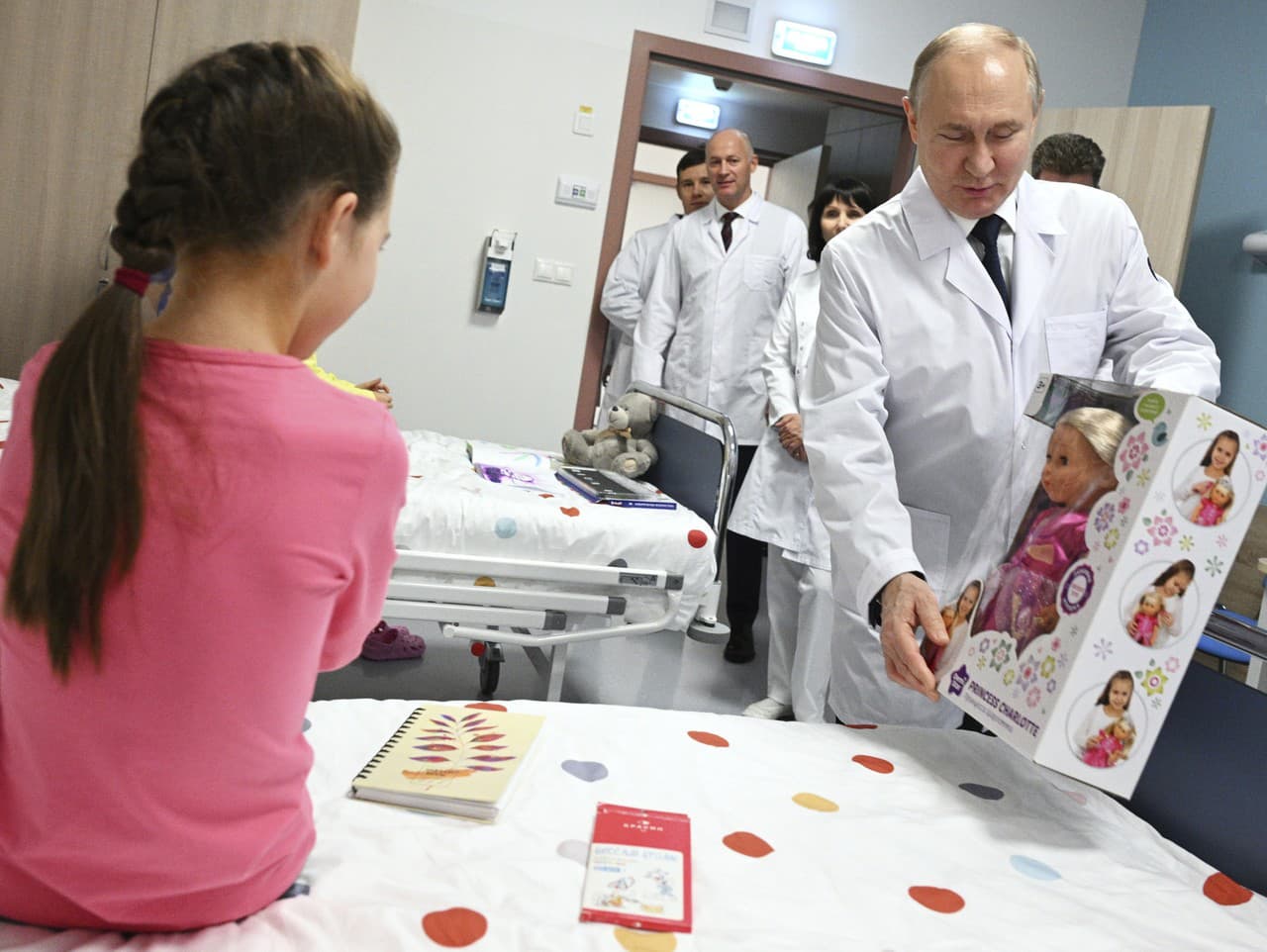 Vladimir Putin odovzdáva pacientke bábiku.