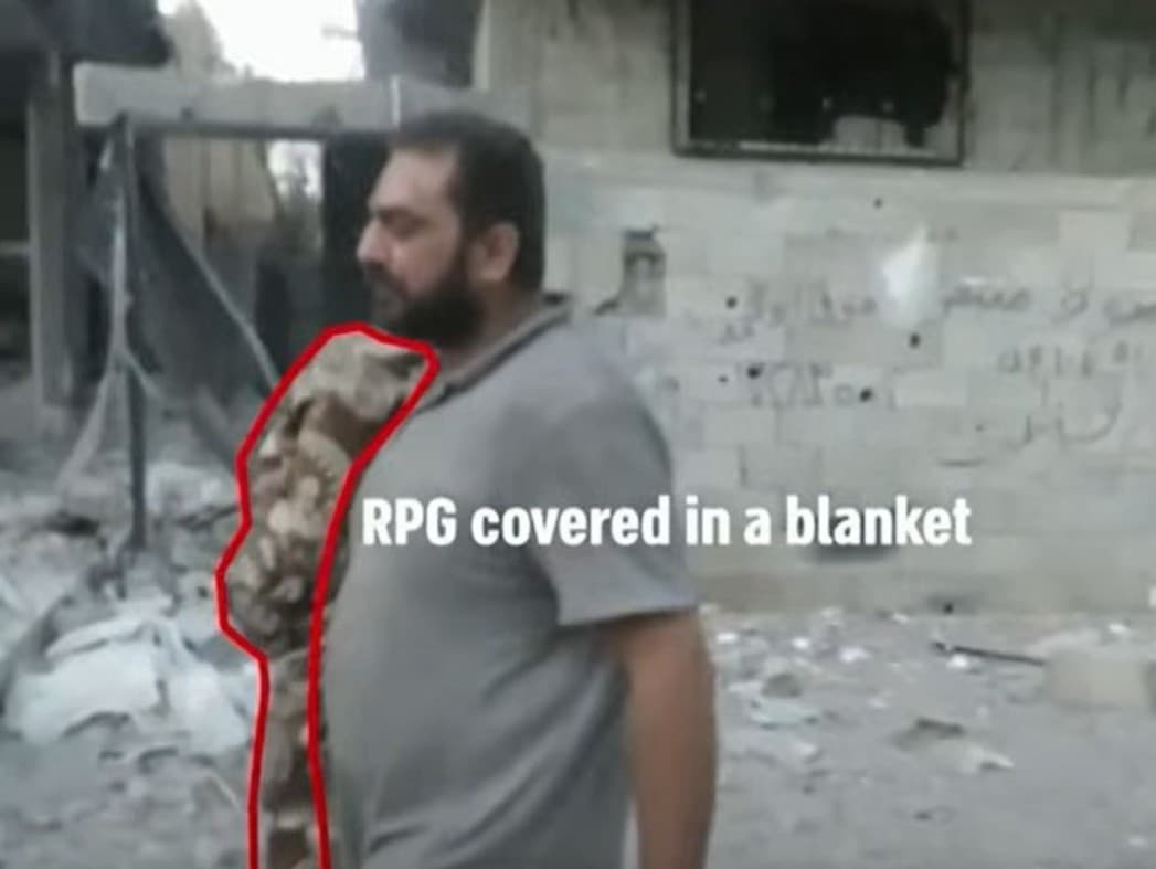 Terorista Hamasu v Pásme Gazy oblečený v civile a s protinkavou päsťou RPG, ktorá je zakrytá prikrývkou. 
