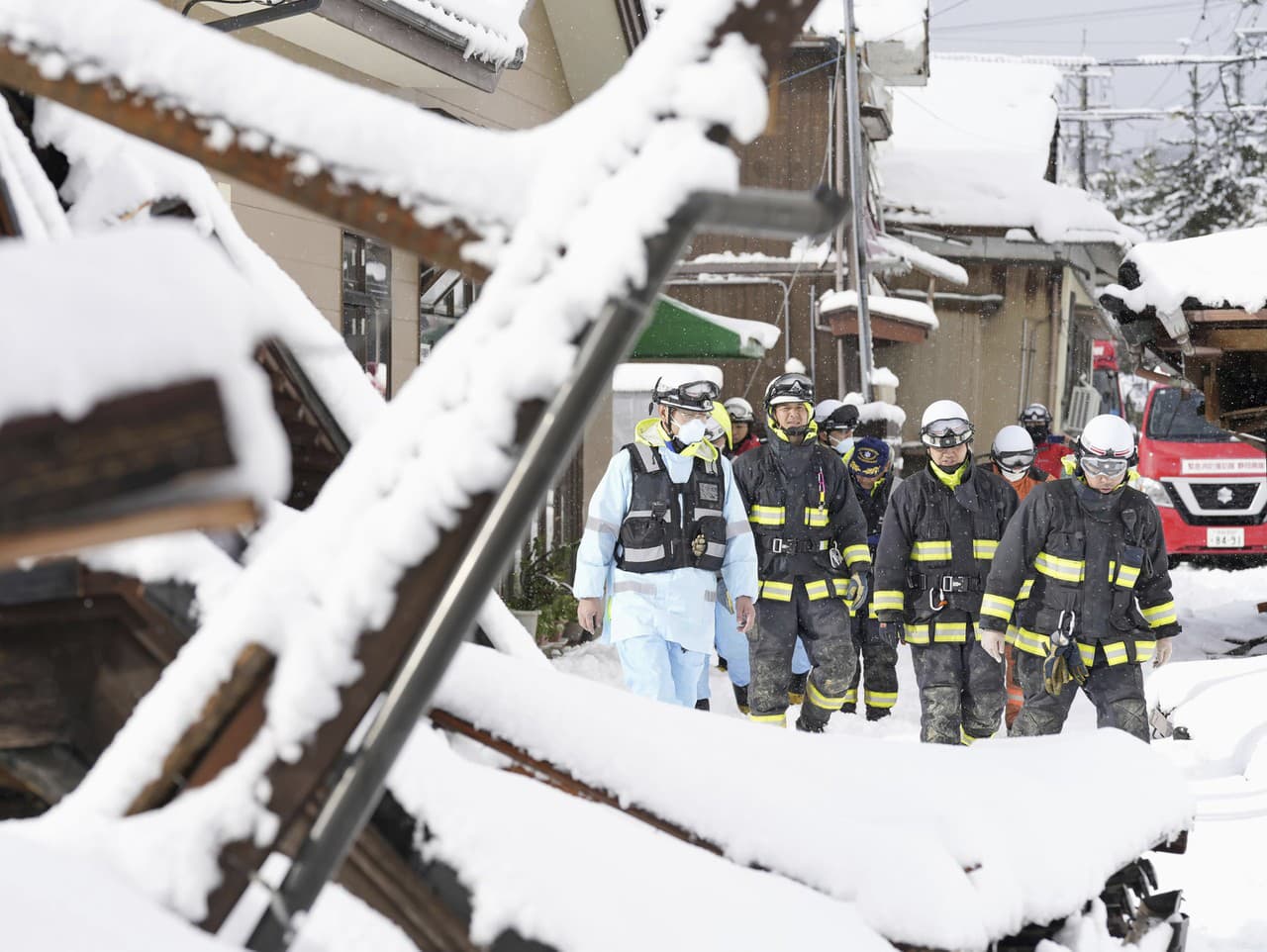 Hasiči prehľadávajú zasypané domy v zemetrasením postihnutom meste Suzu v prefektúre Ishikawa v pondelok 8. januára 2024.