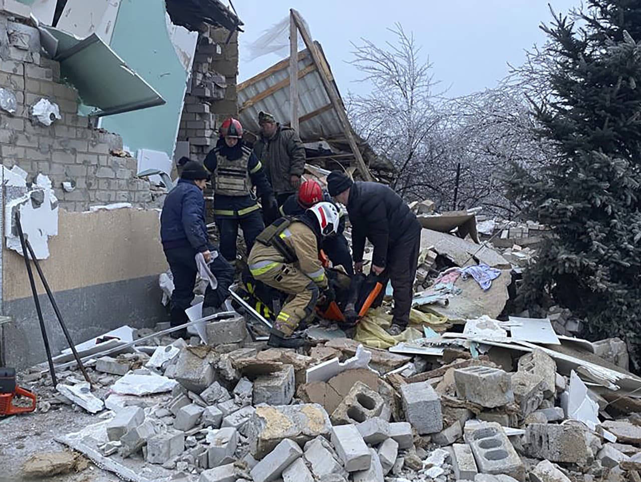 Na snímke poskytnutej ukrajinskou pohotovostnou službou záchranári pomáhajú zranenej osobe po tom, čo obytné domy zničil ruský raketový útok, v Novomoskovsku pri ukrajinskom meste Kryvyj Rih v pondelok 8. januára 2024.