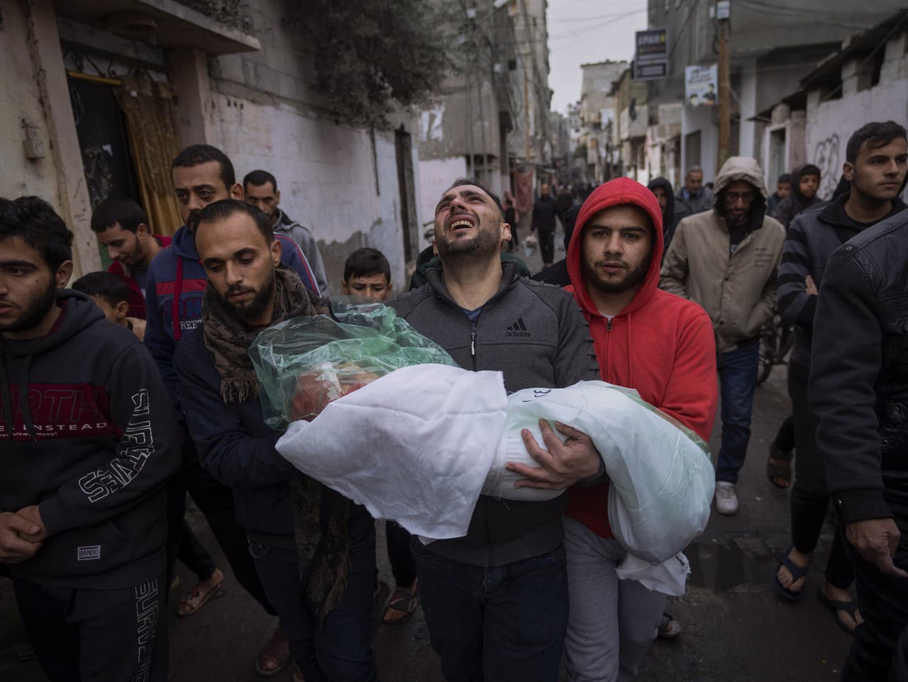 Mohammad Shouman nesie telo svojej dcéry Masa, ktorá zahynula pri izraelskom bombardovaní pásma Gazy, počas jej pohrebu v Rafahu na juhu Gazy v stredu 17. januára 2024.