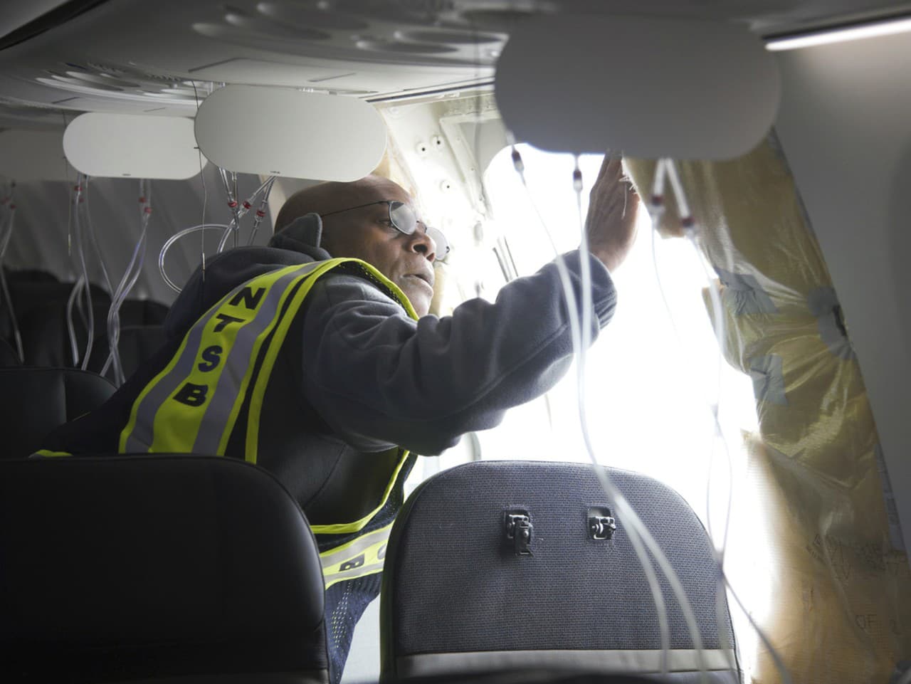 Inšpektori kontrolujú otvor v lietadle.