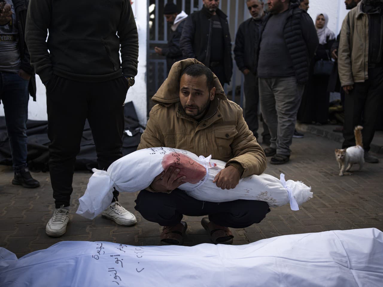 Muž drží telo svojej dcéry, ktorá zahynula pri izraelskom bombardovaní pásma Gazy, v nemocničnej márnici v Rafahu v stredu 21. februára 2024.