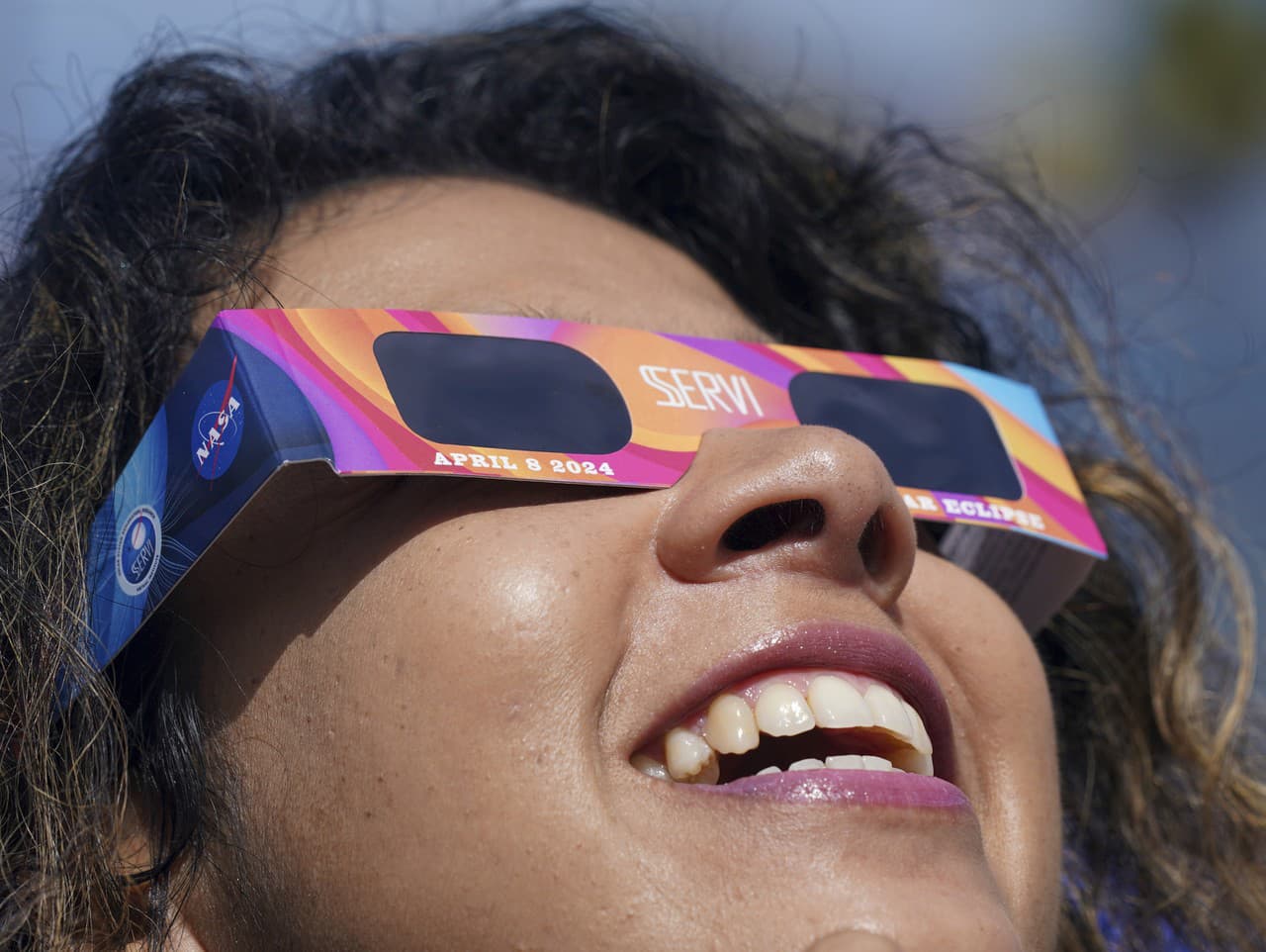 Žena pozerá cez solárne okuliare na úplné zatmenie Slnka v mexickom meste Mazatlan