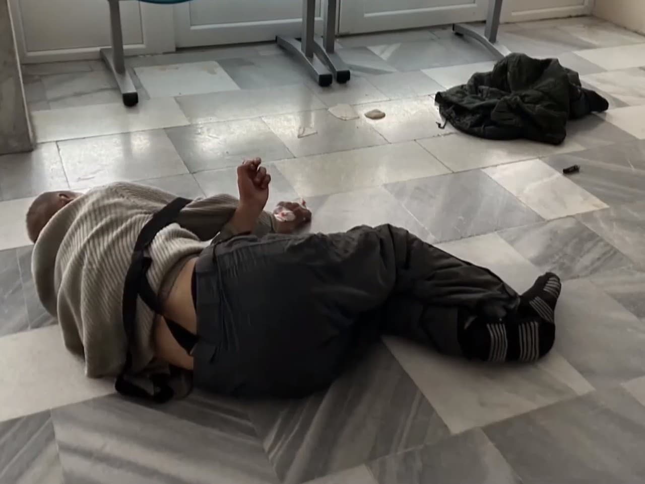 Pán Ladislav ležiaci na podlahe v nemocnici.