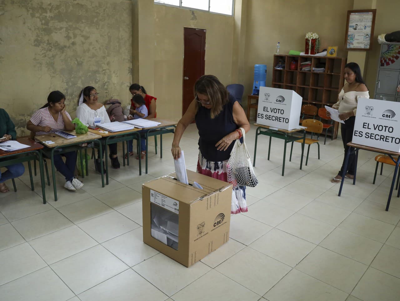 Volička vhadzuje hlasovací lístok počas referenda, ktoré navrhol prezident Daniel Noboa, aby schválil nové bezpečnostné opatrenia zamerané na potlačenie zločineckých gangov, ktoré podnecujú eskaláciu násilia