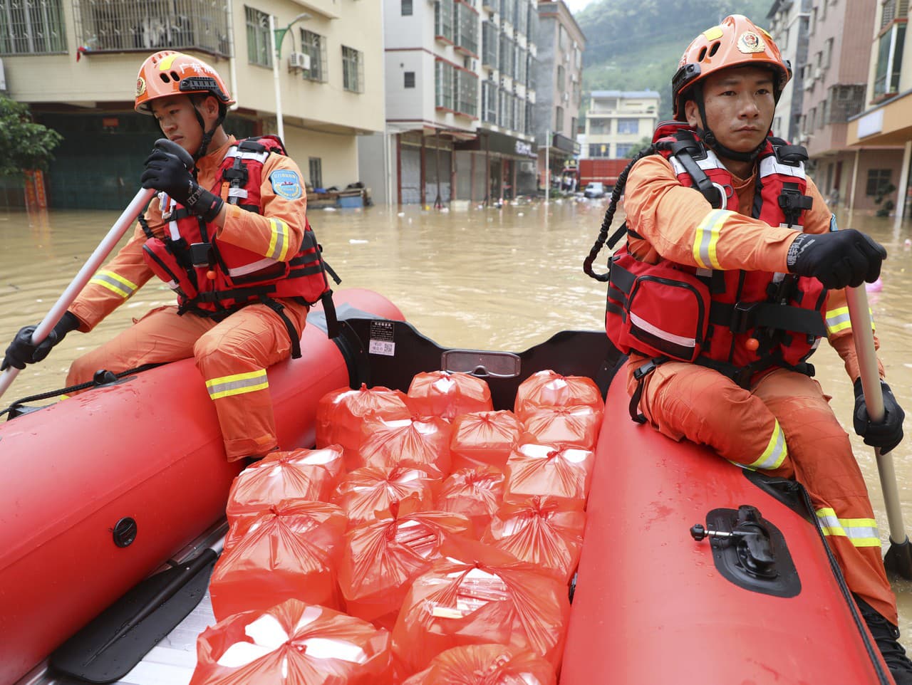 Na snímke záchranári rozvážajú na pltiach potraviny ľuďom postihnutým silnými dažďami v meste Lianjiangkou v juhočínskej provincii Kuang-tung 