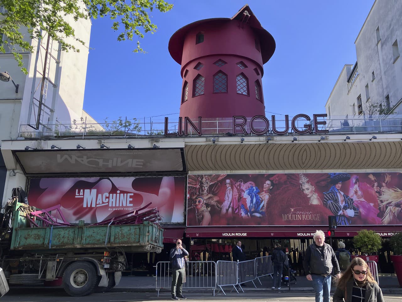 Pohľad na červený veterný mlyn bez vrtule na streche rovnomenného kabaretu Moulin Rouge v Paríži