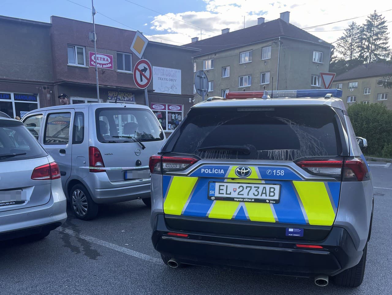 Na snímke policajné auto stráži opáskované auto na parkovisku v blízkosti domu kultúry po streľbe na premiéra Roberta Fica v Handlovej v okrese Prievidza