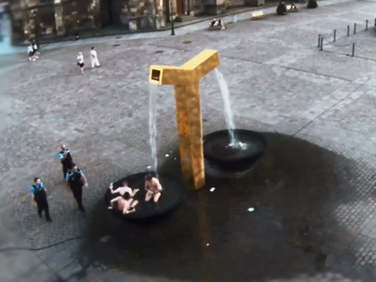 Nemeckí turisti sa kúpu vo fontáne v centre Plzne. Smeruje k nim privolaná hliadka mestskej polície
