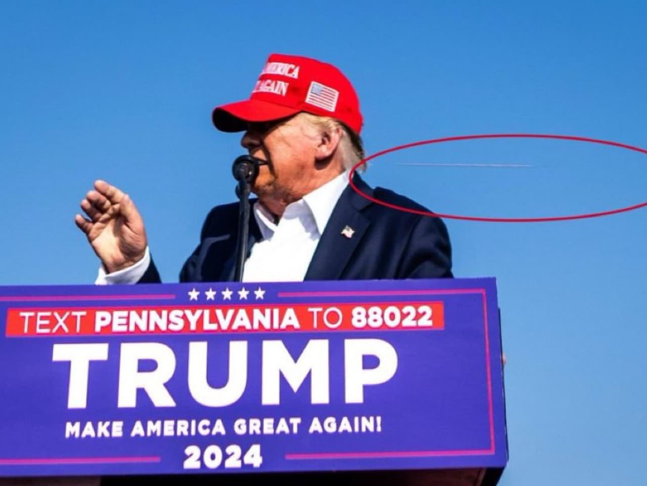 Donald Trump na predvolebnom zjazde v Pensylvánii (Butler). Fotograf zachytil letiacu guľku len pár centimetrov od jeho hlavy