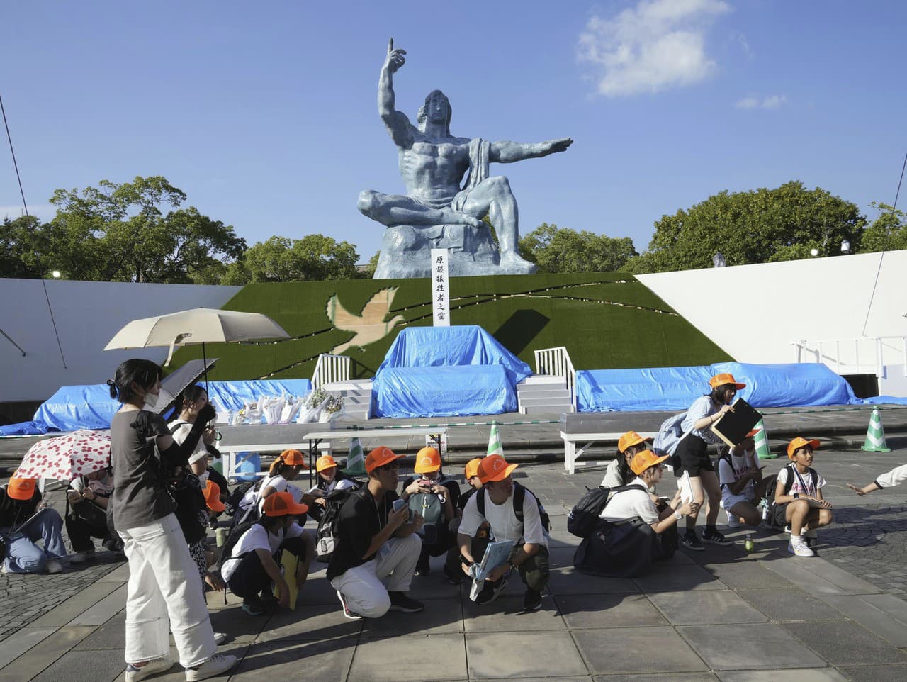 Návštevníci Parku mieru sa krčia po vyhlásení poplachu pred zemetrasením v meste Nagasaki.