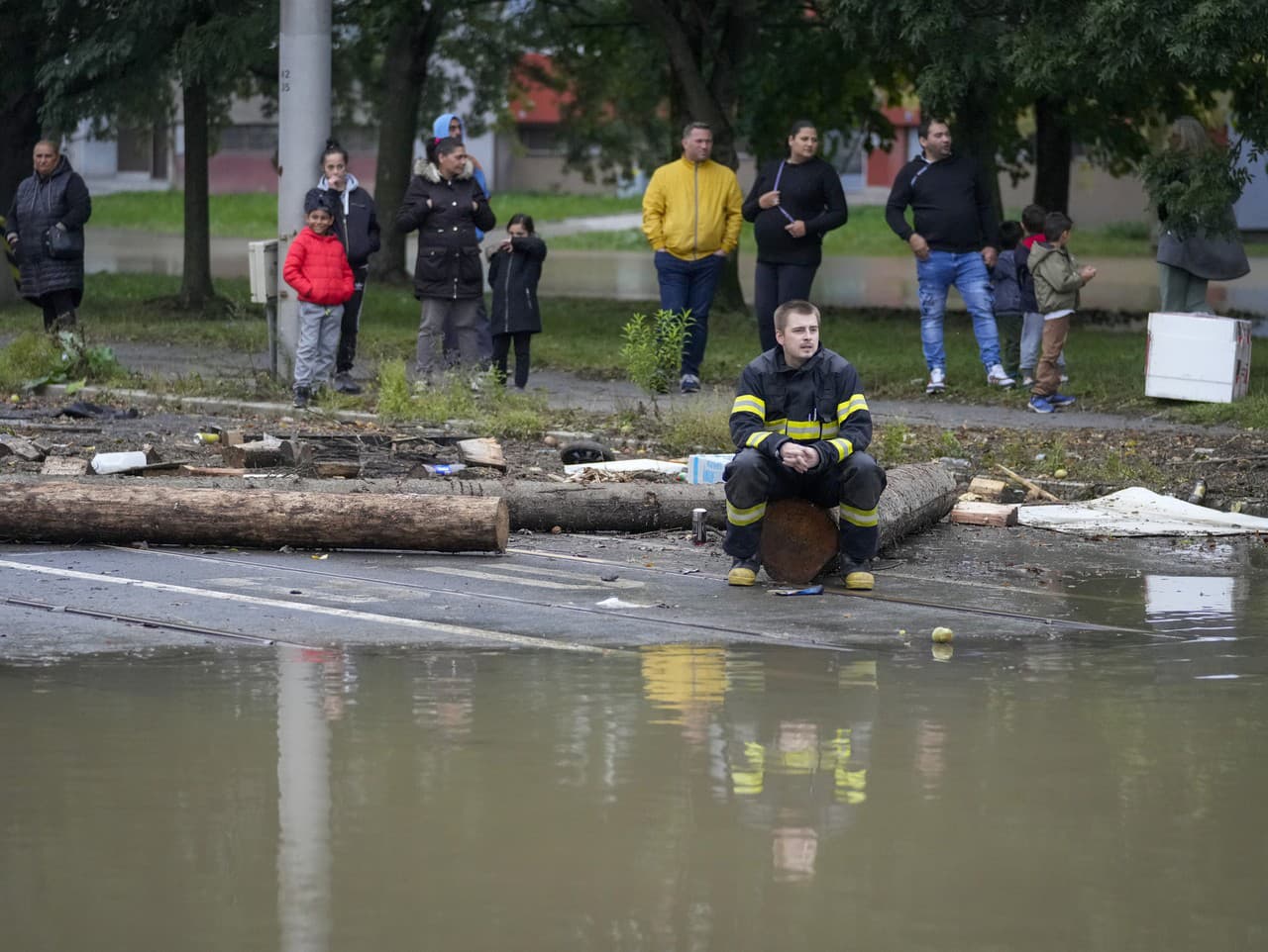 Hasič a obyvatelia sa pozerajú na záplavu v Ostrave 16. septembra 2024.