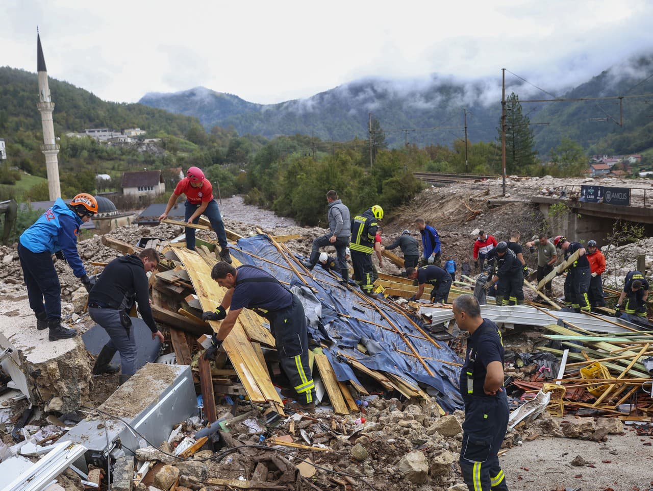 Záchranári prehľadávajú nezvestných v troskách po záplavách a zosuvoch pôdy v bosnianskej dedine Donja Jablanica.