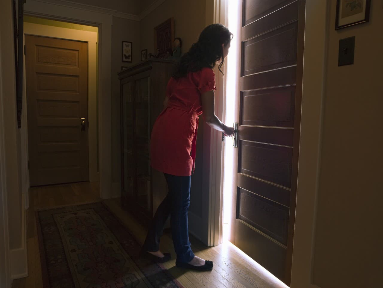 Woman opening bedroom door with light coming out