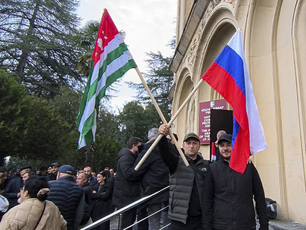 Dvaja demonštranti s abcházskou a ruskou zástavou.