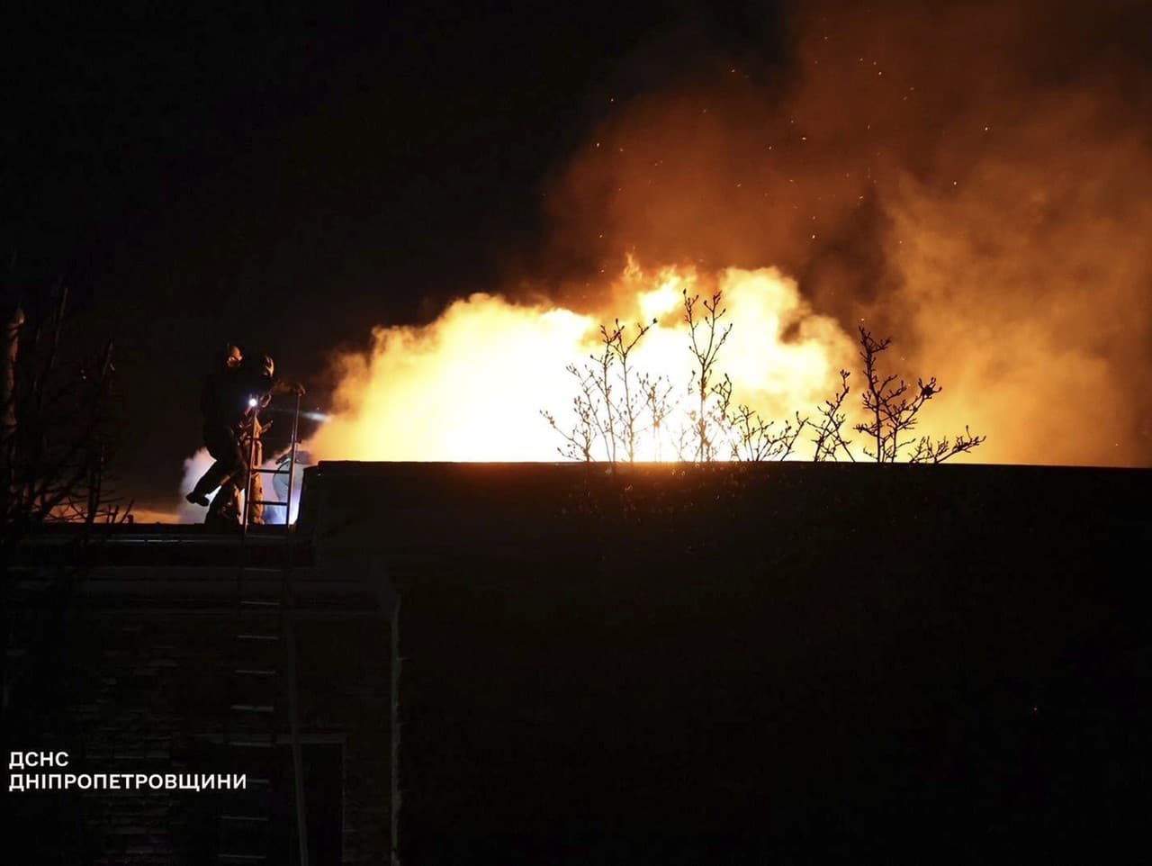 Príslušníci záchranných zložiek hasia požiar domu po leteckom útoku ruskej armády na ukrajinské mesto Dnipro