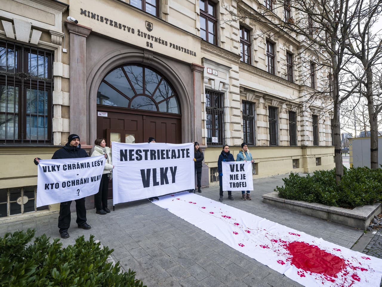 Účastníci s transparentami pred budovou ministerstva životného prostredia SR počas spoločnej tlačovej konferencie na tému – Nestrieľajte vlky!