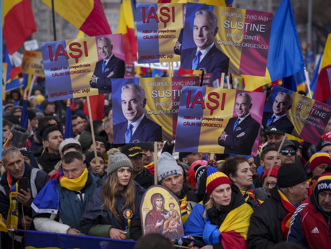 Ľudia držia fotografie Calina Georgesca, víťaza prvého kola prezidentských volieb, ktoré neskôr Ústavný súd zrušil, počas protestu pred sídlom vlády.